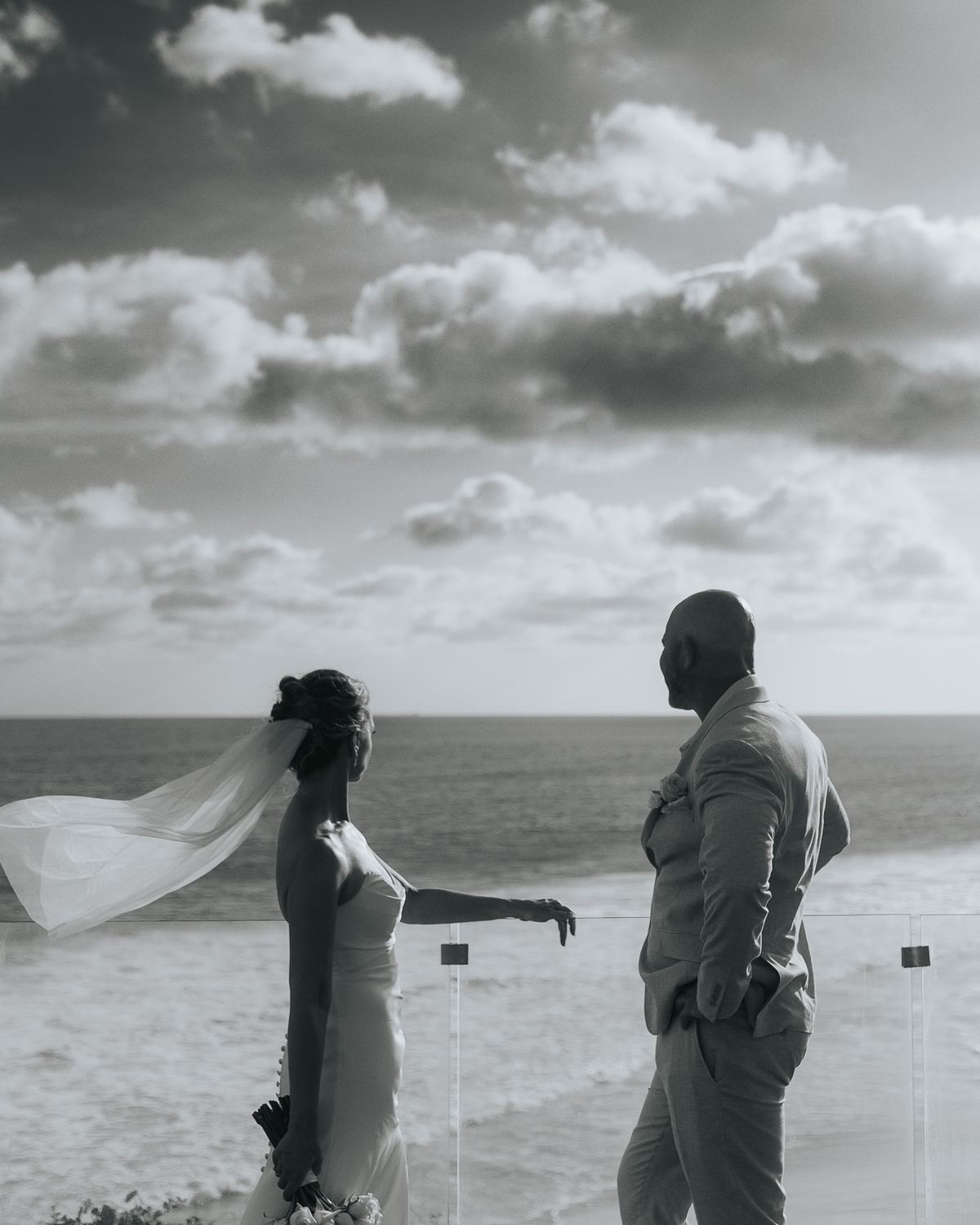 Bride's veil lifting in the wind at a beach ceremony