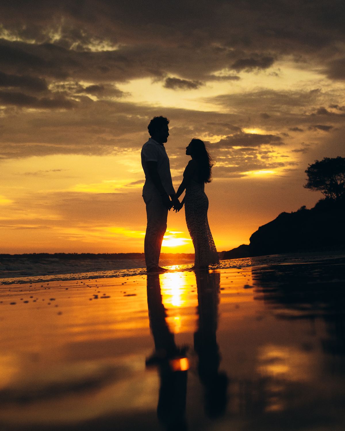 Couple silhouetted at sunset over the bay