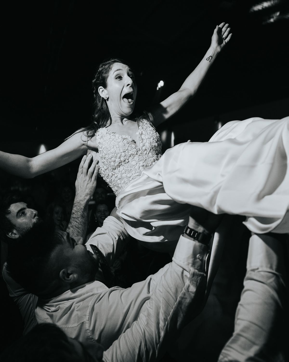 Guests lifting the bride on the dance floor